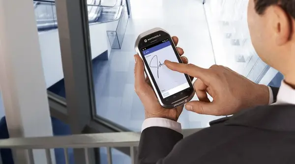 Man signing for package delivery on his cell phone