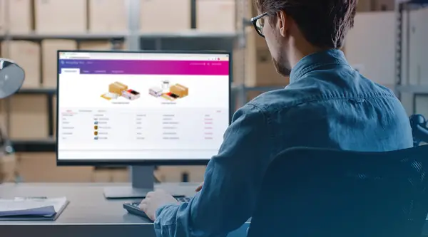 man in a warehouse looking at Pitneyship dashboard on his computer screen